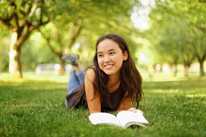 High school student reading outside over summer break