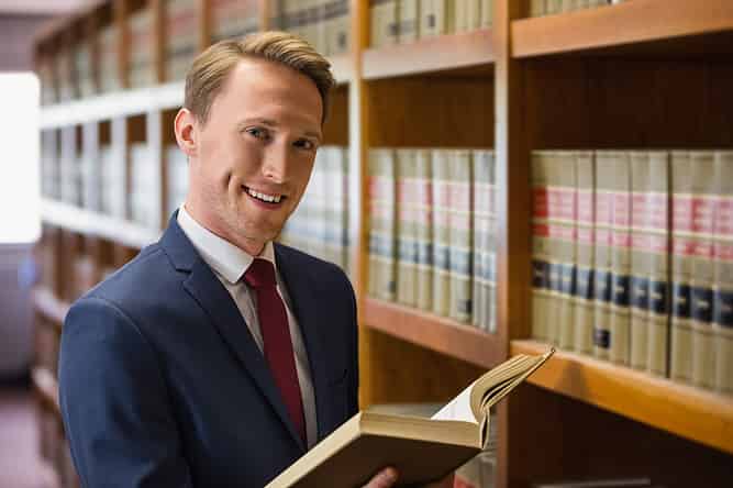 Prospective law student reviews a book in the university law library