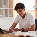 Portrait of Vietnamese student concentrated on essay