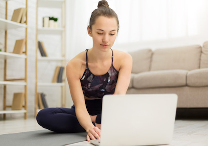 Woman taking break from exercises, watching online lesson