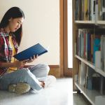 University students reading books for research and a variety of research resources in the library to support reports, assignments, papers, essays, and submissions for classes. The notion of education research is self-learning.
