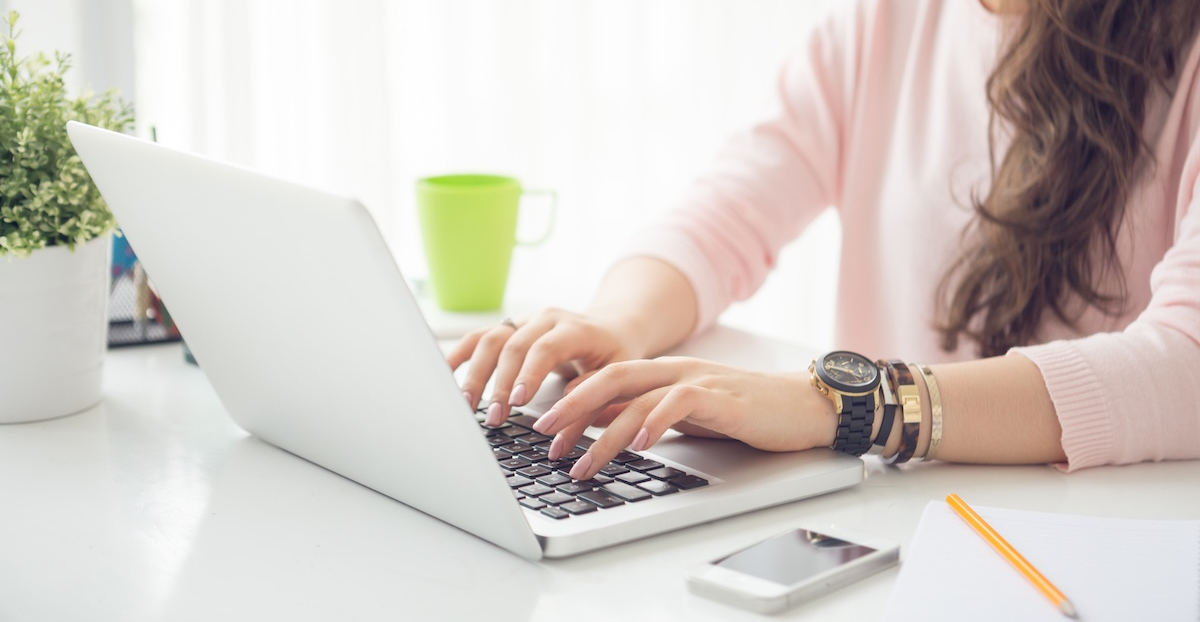 Cropped image of female college student working on laptop