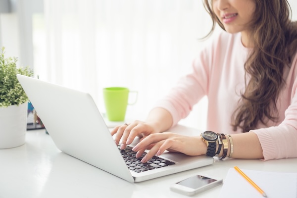 Cropped image of female college student working on laptop