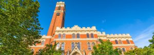 Campus building with clock tower against a clear blue sky.