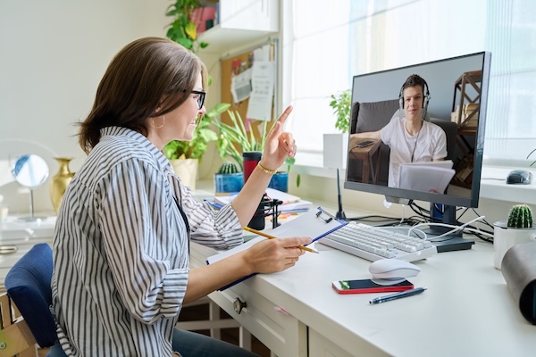 woman counseling teenage male virtually