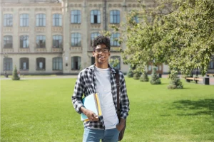 Smiling student on campus with books, ready for college success.