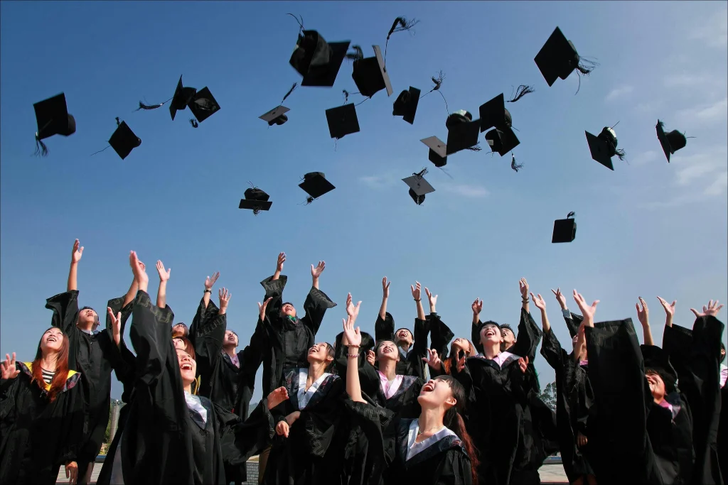 Joyful graduates celebrating academic achievement by throwing caps into the sky