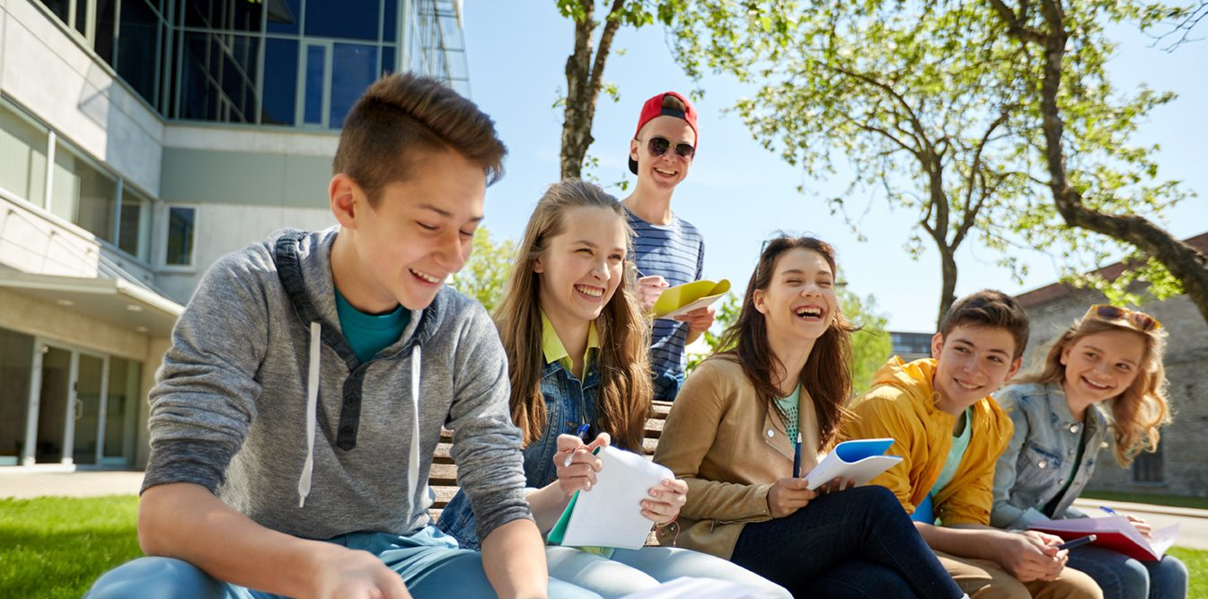 group of 8th graders with notebooks at school yard