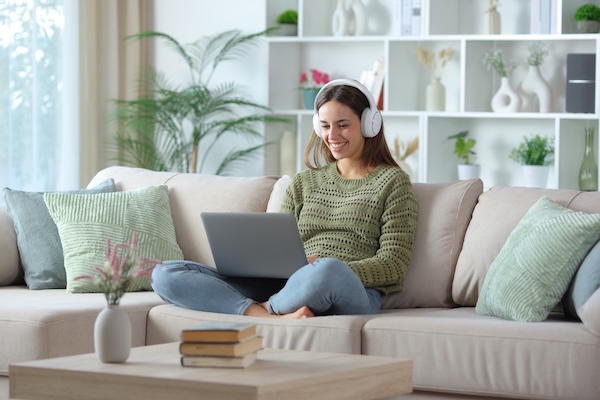Beautiful casual student using laptop indoors.